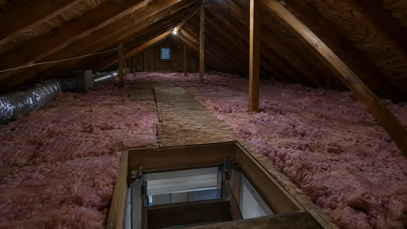 Surface view: an attic underside with dark nail tips and stained decking